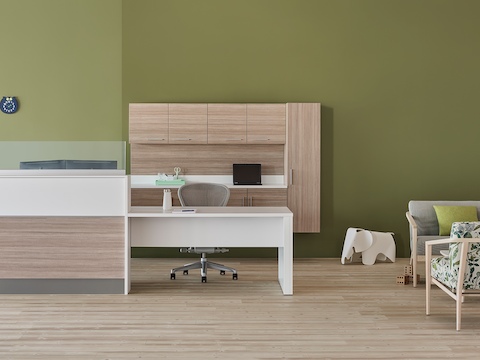 A prefab Commend Nurses Station with glass screens serving as a reception desk in an outpatient space including Palisade chairs, sofa, and table. A prefab Commend Nurses Station with glass screens serving as a reception desk in an outpatient space including Palisade chairs, sofa, and table.