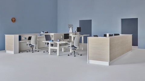 A caregiver team environment with a white and wood laminate prefab Commend Nurses Station, Verus Chairs, Renew Link, and Renew Sit-to-Stand Tables.