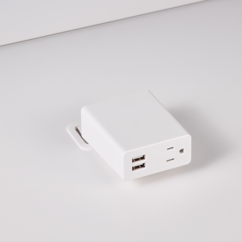 A close-up view of Logic Mini Surface Clamp with two USB ports and one power outlet integrated into the top of a white laminate work surface.