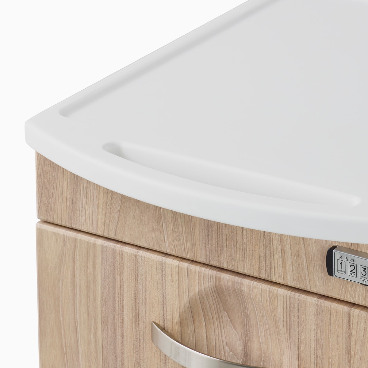 A close-up view of the solid surface, integrated top surface and pull of a Compass casework supply cart in a warm elm finish.