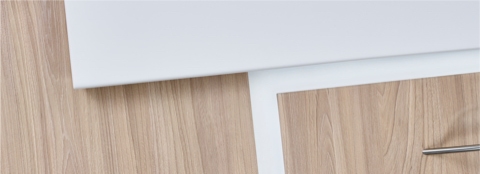 A close-up view of Compass materials with a tile and drawer in an elm finish and a Corian surface in a white finish.