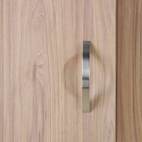 A close-up view of a Compass System wardrobe cabinet in a medium wood finish.