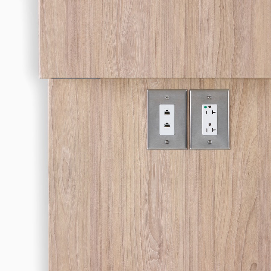 Close-up of power and data outlet access on Compass System in a medium wood finish.