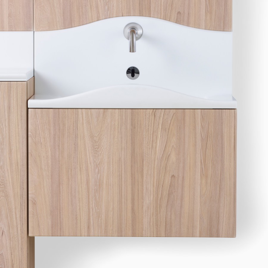 Close-up of white Corian sink in Compass System in a medium wood finish.