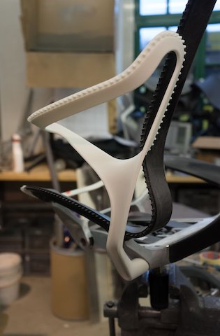 Een close-up van een prototype van de bladarm op een Cosm-stoel.