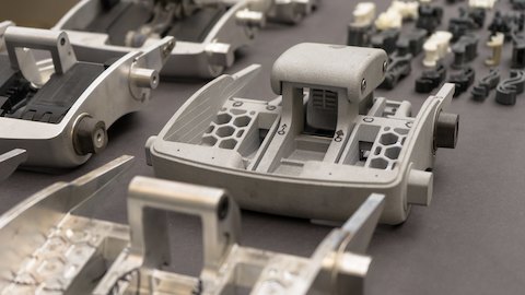 Een aantal componenten en prototypen van de automatisch afstellende kanteling zitten op een werkbank.