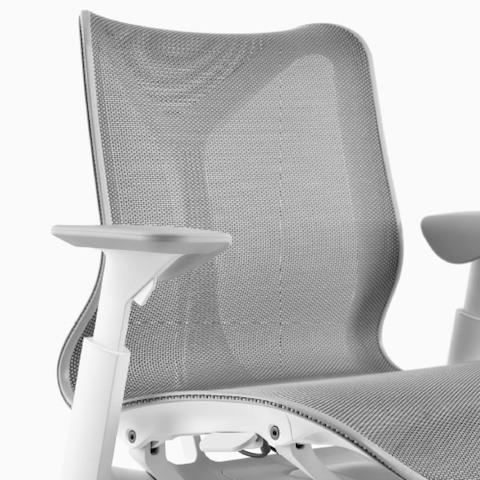 Una silla baja con respaldo Cosm con brazos ajustables en altura, y marco Studio White y material de suspensión Mineral.