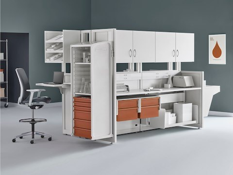 Soft white Co/Struc System with terra cotta storage drawers with a dark gray Verus Stool and wire storage system in an alcove of a medical laboratory. Soft white Co/Struc System with terra cotta storage drawers with a dark gray Verus Stool and wire storage system in an alcove of a medical laboratory.