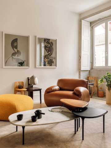 Luva modulaire sofa, fauteuil in een woonkamer met Cyclade-tafels in walnootbruin, ebbenhout en marmer.