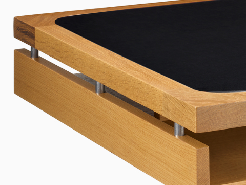 Detail of the Eames 2500 Series Executive Desk in oak with black leather inlay.