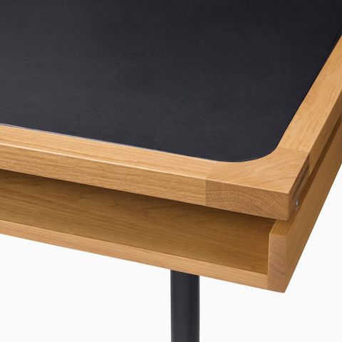Detail of the Eames 2500 Series Executive Desk in oak with black leather inlay.