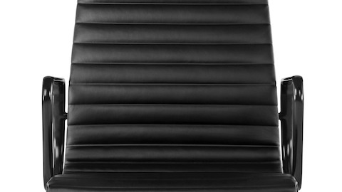 The back of an Eames Aluminum Group Chair in premium black leather. The back of an Eames Aluminum Group Chair in premium black leather.