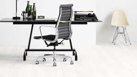 黒Eames Aluminum Groupチェア、黒AGLテーブル、白Eames成形ガラス繊維椅子と小さなオフィス。