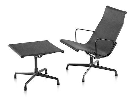 An Eames Aluminum Group outdoor lounge chair and ottoman in a black weave fabric.