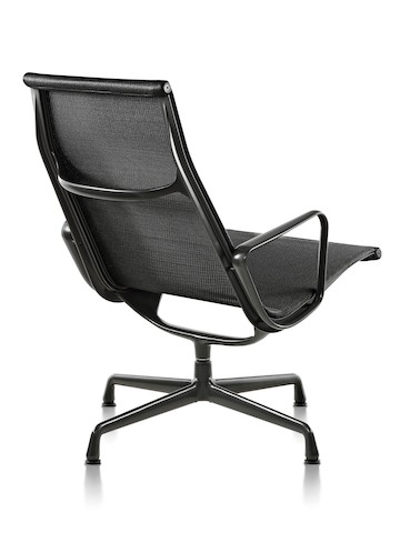 Three-quarter rear view of an Eames Aluminum Group outdoor lounge chair in a black weave fabric. 