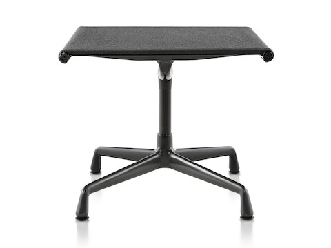 An Eames Aluminum Group outdoor ottoman in a black weave fabric. 