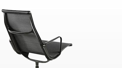 Three-quarter rear view of an Eames Aluminum Group outdoor lounge chair in a black weave fabric. Three-quarter rear view of an Eames Aluminum Group outdoor lounge chair in a black weave fabric.