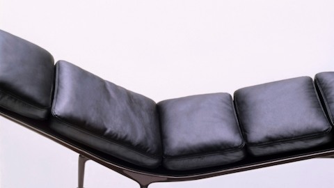 An overhead profile view of a black leather Eames Chaise with an eggplant frame. An overhead profile view of a black leather Eames Chaise with an eggplant frame.