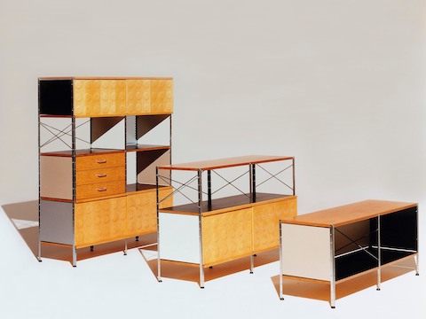 Três unidades de armazenamento Eames de vários tamanhos, todas em esquemas de cores neutras com detalhes em bétula, preto e branco.