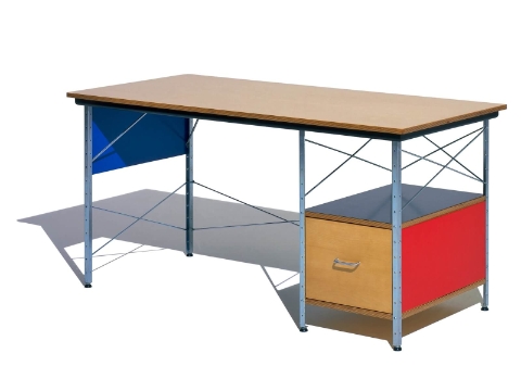 Uma visão angular de um Eames Desk em um esquema de cores brilhantes com acentos de bétula, vermelho, preto e azul.