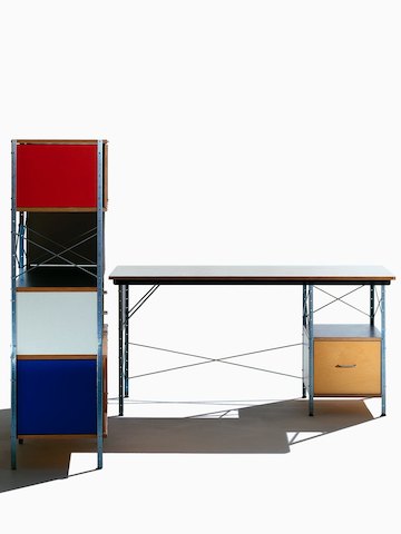 Vista frontal de una mesa Eames en colores neutros junto a una unidad de almacenamiento Eames con acentos brillantes, que se muestra de costado.