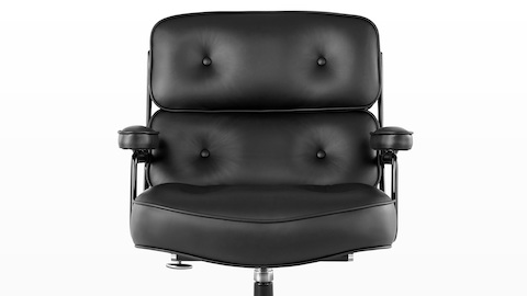 Close view of a black leather Eames Executive Chair, showing the thickly padded seat, back, and arms.