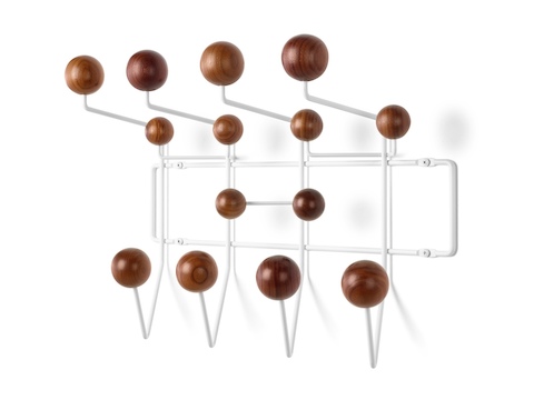 Visão angular de um rack de armazenamento Eames Hang-It-All, com uma moldura de arame branco e botões de madeira em um acabamento médio.