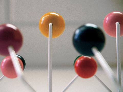 Eames Hang-It-All収納ラックの部分背面図で、白いワイヤフレームと多色の木製ノブを示しています。