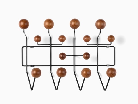 Um rack de armazenamento Eames Hang-It-All, com armação de arame preto e botões de madeira em um acabamento médio.