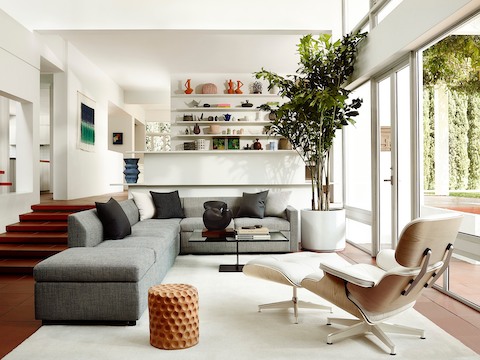 Eames休闲椅和奥斯曼在住宅环境中的白色皮革的四分之三后视图。