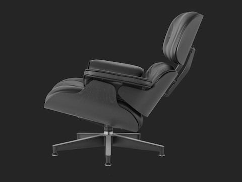 Profile view of a black leather Eames Lounge Chair with a black shell. Profile view of a black leather Eames Lounge Chair with a black shell.
