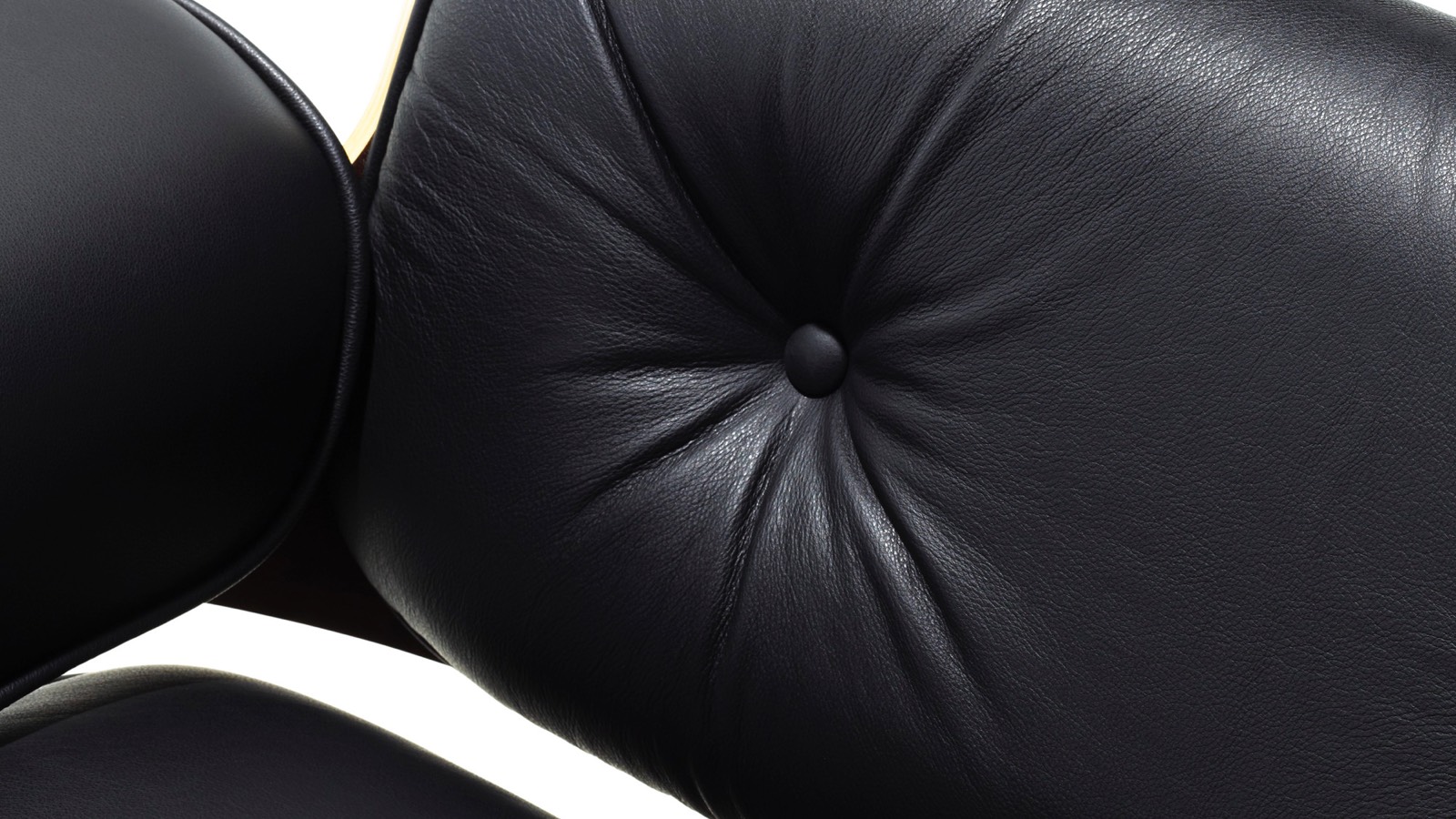 Close-up of the black leather upholstery on an Eames Lounge Chair. 