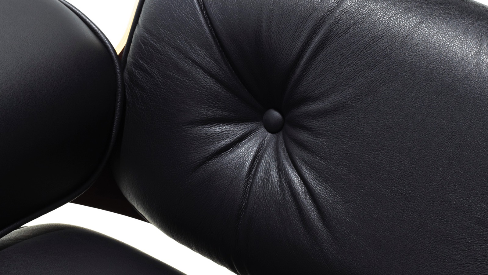Close-up of the black leather upholstery on an Eames Lounge Chair. Close-up of the black leather upholstery on an Eames Lounge Chair.