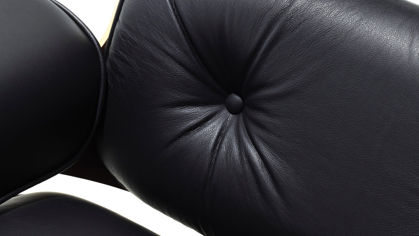 Close-up do estofamento de couro preto em uma Eames Lounge Chair.