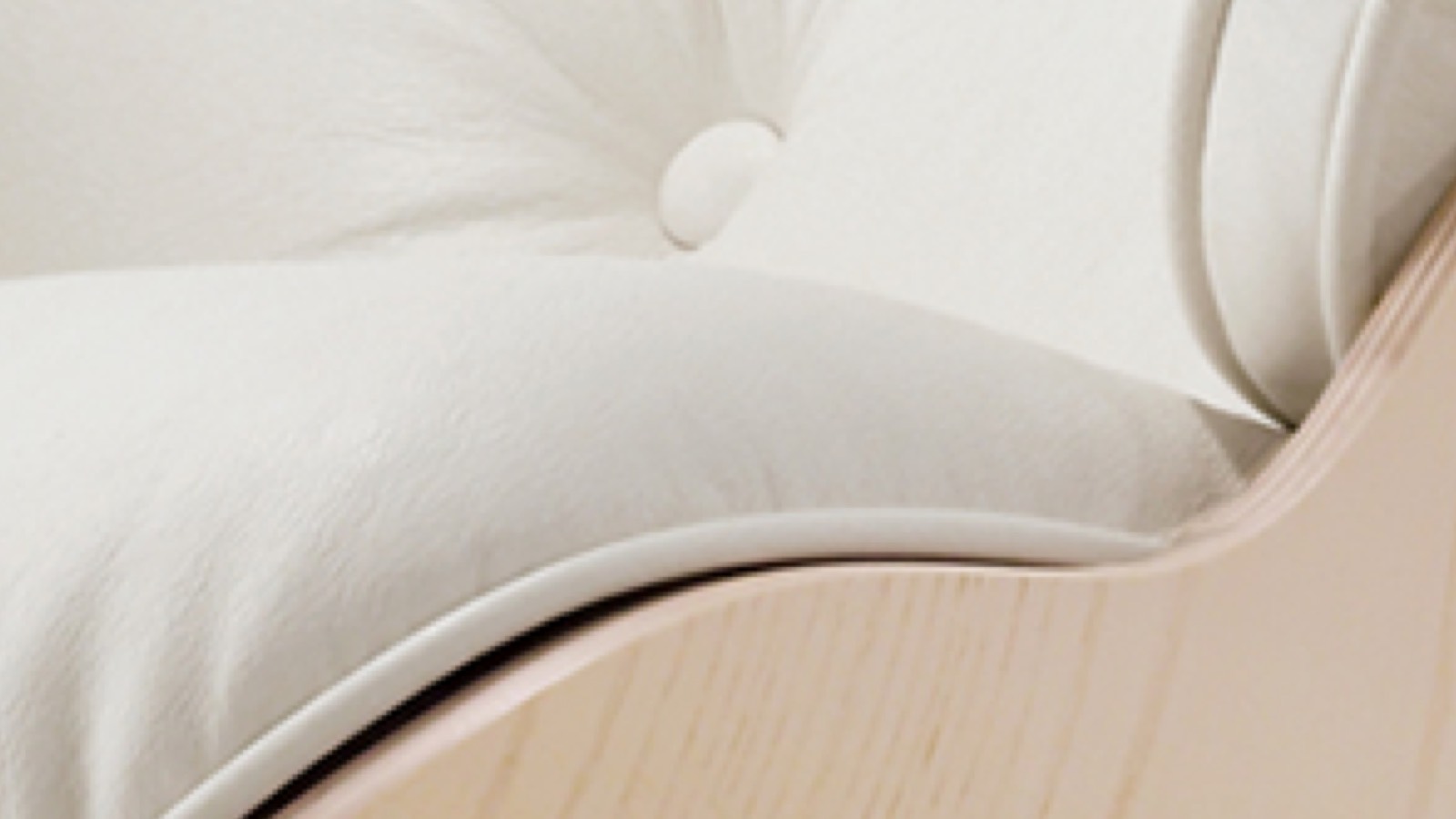 Close-up of the white leather upholstery on an Eames Lounge Chair. 