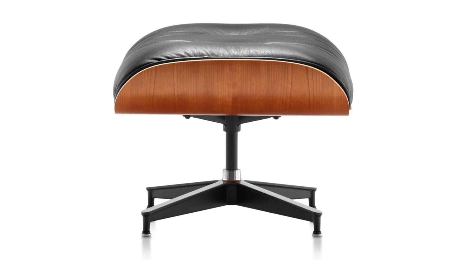 Black leather Eames Ottoman with a wood veneer shell, viewed from the side. 