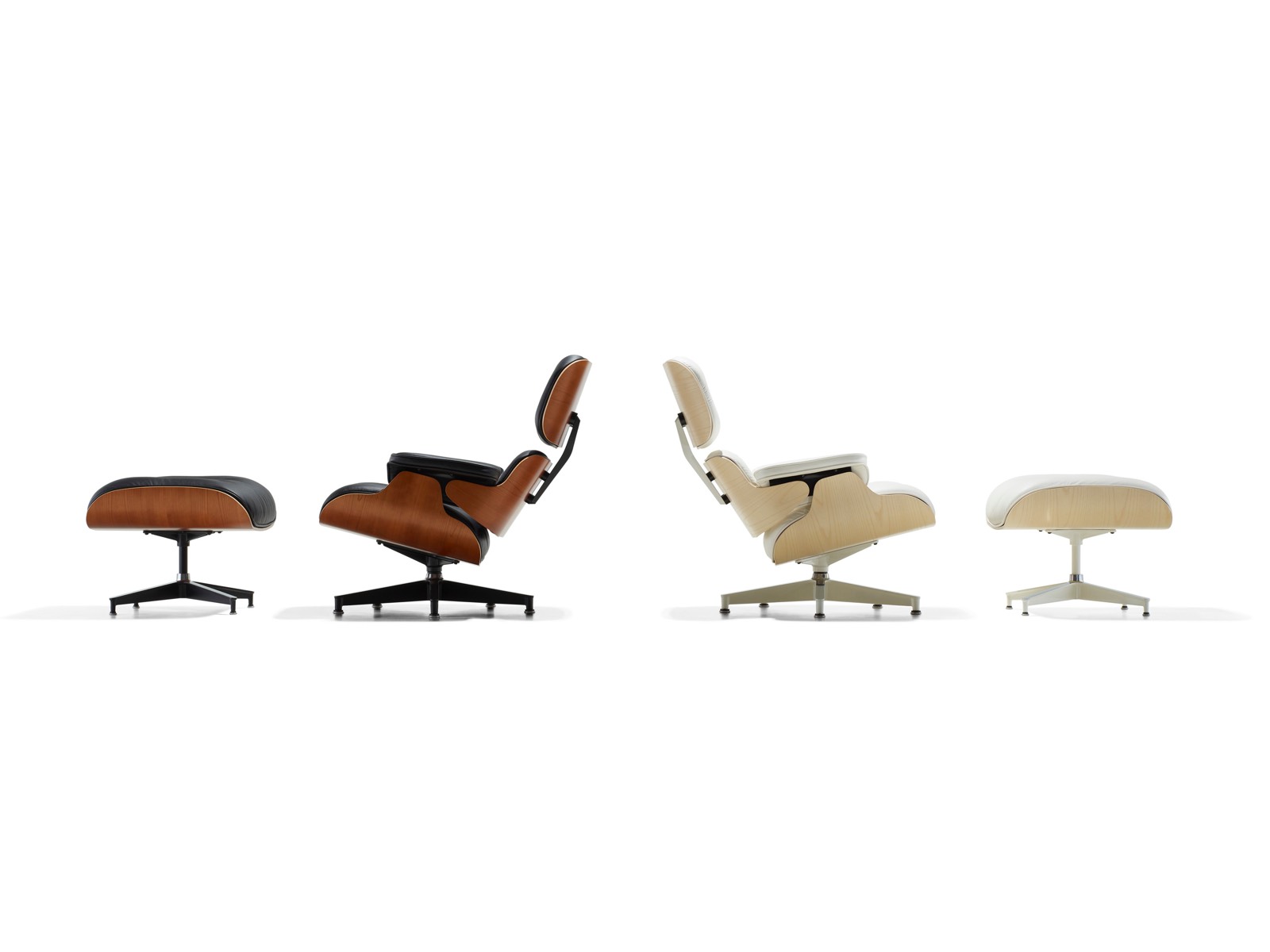 Un sillón y otomano Eames de cuero negro y un sillón y otomano Eames de cuero blanco, colocados espalda con espalda.