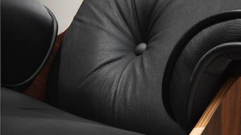 Close view of the black leather upholstery on an Eames Lounge Chair. 