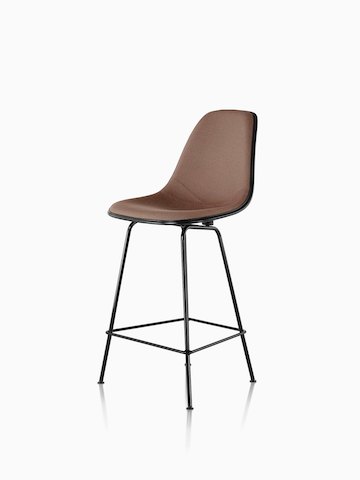 黑色Eames模制玻璃钢凳子，棕色装饰，从45度角看。