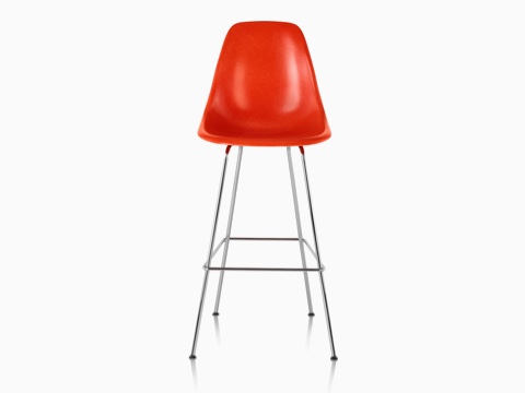 La mitad superior de un taburete de fibra de vidrio moldeado Eames rojo, visto desde el frente. La mitad superior de un taburete de fibra de vidrio moldeado Eames rojo, visto desde el frente.