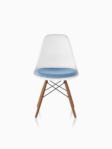 白色Eames从前面看，模塑塑料侧椅带浅蓝色软垫坐垫和木钉腿。