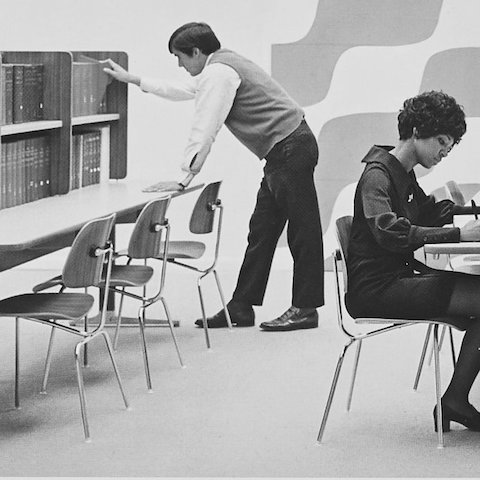 Woman working at desk in an EC-127 chair, archival imagery.