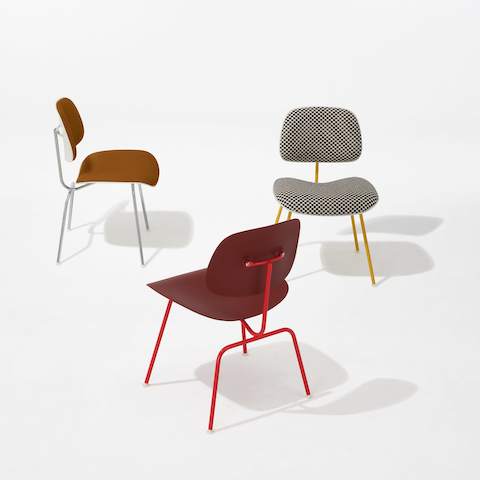 Three Eames Molded Plastic Dining Chairs EC-127 including an all red chair, an upholstered orange chair with white shell, and black and white checkered chair with yellow frame.