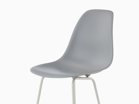 La mitad superior de un taburete de plástico moldeado Eames azul claro, visto desde un ángulo de 45 grados.