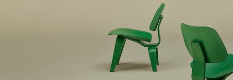 Green Eames Molded Plywood Chairs on sage background.