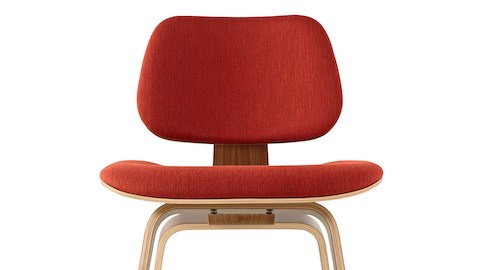 Vista próxima da metade superior de uma cadeira de compensado moldado Eames com estofamento vermelho.