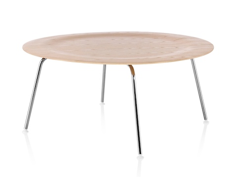 A round Eames Molded Plywood Coffee Table with metal legs and an indented top in a light finish. 