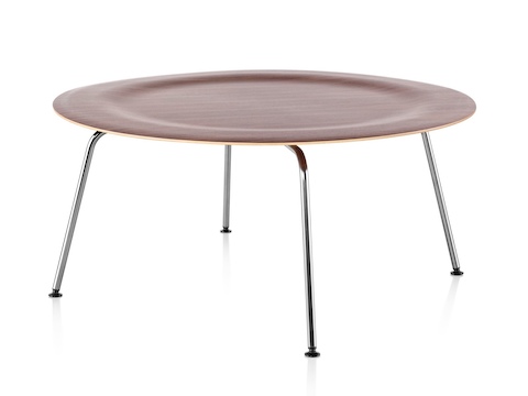 Uma mesa de café de contraplacado moldado Eames redonda com pernas de metal e um top recuado em um acabamento médio.