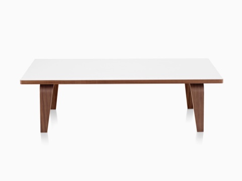 Una mesa de centro rectangular Eames con una parte superior blanca y patas de madera contrachapada moldeadas en un acabado medio.