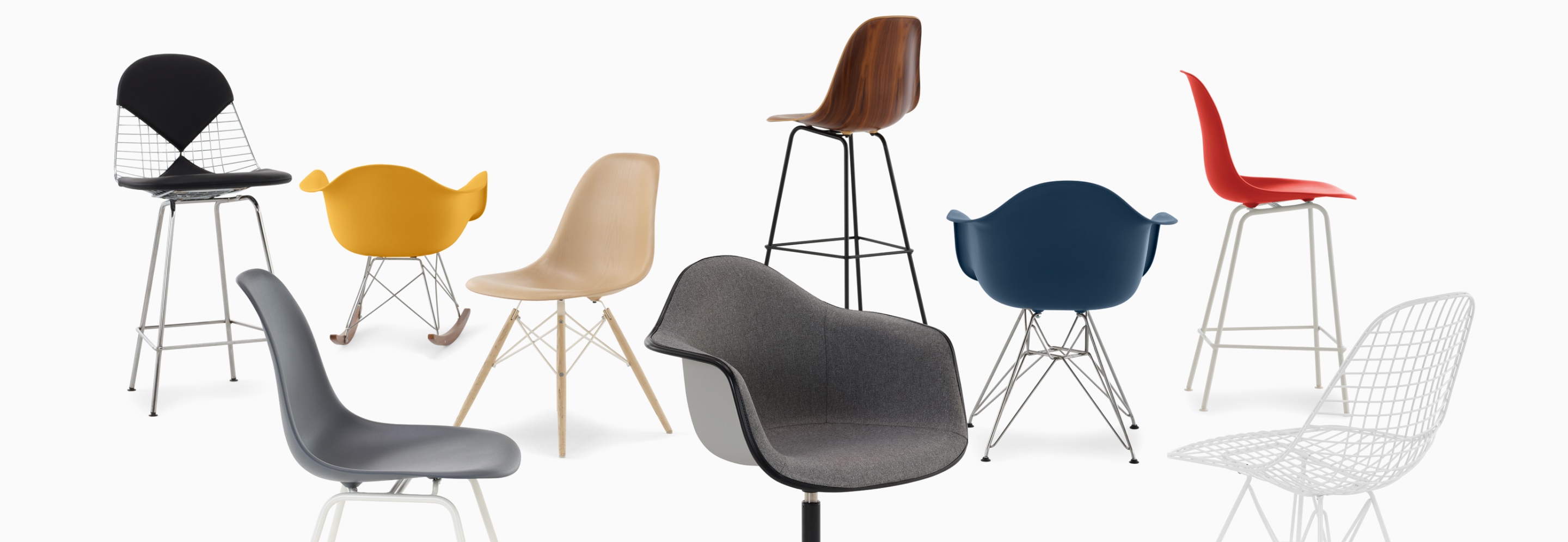 A casual arrangement of Eames shell chairs and stools in fibreglass, wire, wood and plastic.